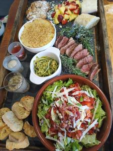 - un plateau de nourriture avec salade, viandes et autres aliments dans l'établissement Le Pavillon des pivoines, à Hyères