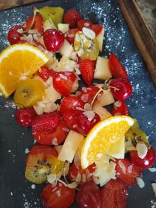 un plato de fruta con naranjas, fresas y cerezas en Le Pavillon des pivoines, en Hyères