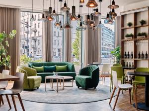 a living room with green furniture and large windows at Holiday Inn - Warsaw City Centre, an IHG Hotel in Warsaw