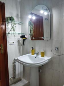een badkamer met een witte wastafel en een spiegel bij Centrico y acogedor, Posibilidad parking 10 euros dia in Vigo
