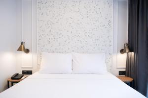 a bedroom with a white bed and a wall at Persona Hotel Galata in Istanbul