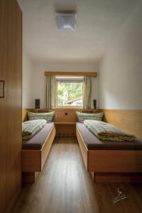 two beds in a room with a window at Ferienwohnung Kobler in Landeck