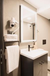 a bathroom with a sink and a mirror and towels at Persona Hotel Galata in Istanbul