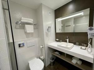 a bathroom with a toilet and a sink and a mirror at Dormy House in Étretat +37 photos