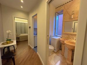 een badkamer met 2 wastafels, een toilet en een raam bij Appartme Stampa 2 in Milaan +6 foto's