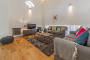 a living room with a couch and a table at Tun House in Letheringsett