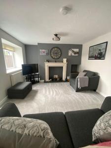 a living room with a couch and a fireplace at Stunning Two bed cottage in Rhuddlan