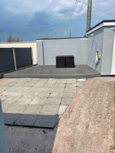 a patio with a building and a black object on it at Stunning Two bed cottage in Rhuddlan