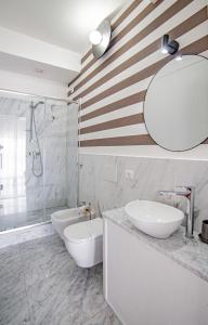 uma casa de banho branca com 2 lavatórios e um espelho em Splendida camera vista mare con terrazza e finiture di lusso em Marina di Carrara