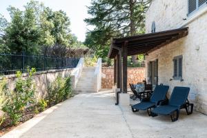 a patio with two blue chairs and a table at Casa Alina by Wonderful Italy in Fasano
