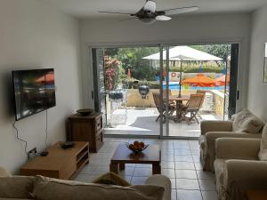 a living room with a couch and a table with an umbrella at Paradeisos is a stunning 2-Bed House in Polis in Polis Chrysochous