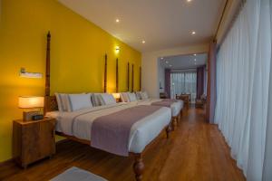 a group of four beds in a hotel room at Morning Dew Boutique Hotel Ella in Ella