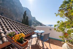 balcón con mesa, sillas y montaña en Hotel Villa Annalara charme and relax en Amalfi