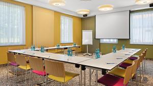 ein großer Konferenzraum mit einem langen Tisch und Stühlen in der Unterkunft Hey Lou Hotel Piding in Piding