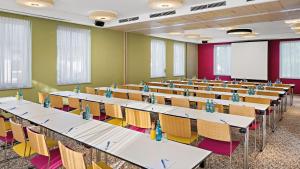 une salle de classe avec rangées de tables et de chaises dans l'établissement Hey Lou Hotel Piding, à Piding