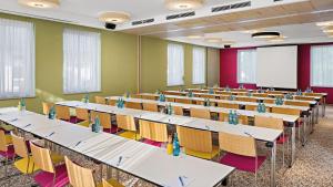 uma sala de aula com fileiras de mesas e cadeiras em Styles Hotel Piding em Piding
