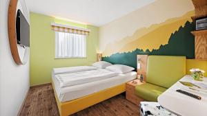 ein Schlafzimmer mit einem Bett und einem Gemälde an der Wand in der Unterkunft Hey Lou Hotel Piding in Piding + 24 Fotos