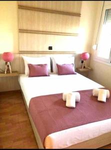 ein großes weißes Bett in einem Zimmer mit 2 Stühlen in der Unterkunft Villa Marina in Perama