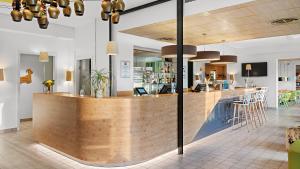 a bar with a wooden counter in a room at Hey Lou Hotel Piding in Piding