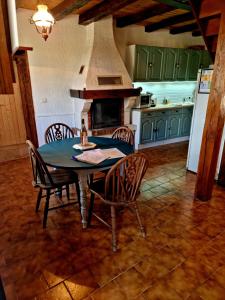 a kitchen with a table and chairs and a stove at Maison de campagne à 15 km du ZooParc de Beauval in Luçay-le-Mâle +4 photos