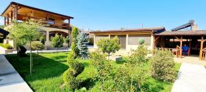 a house with a yard with trees and bushes at Elival House in Nufăru