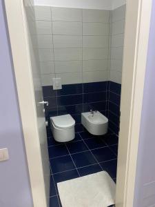 a blue tiled bathroom with a toilet and a bidet at AMMEN Rooms in Shëngjin