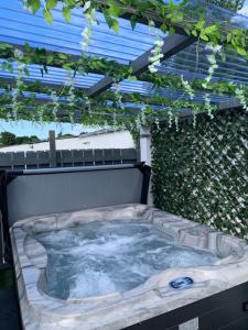 a jacuzzi tub in a backyard with a pergola at Farsnagh Cottage 
