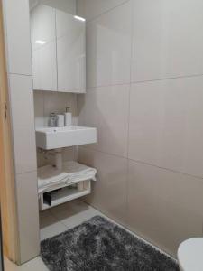 a white bathroom with a sink and a shower at Modern Apartment in Chapel Towers (with Inverter) in Cape Town