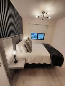 ein Schlafzimmer mit einem großen Bett und einem Fenster in der Unterkunft Modern Apartment in Chapel Towers (with Inverter) in Kapstadt