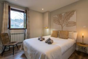 a bedroom with a large white bed and a window at El Encanto del 12 by Unique Rooms in Burgos