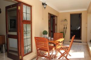 a wooden table and chairs on a patio at LUXURY ROOM @ 4 STAR GUEST HOUSE in Middelburg