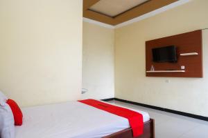 スラカルタにあるRedDoorz near Candi Sukuh Karanganyarのベッドルーム1室(ベッド1台、壁掛けテレビ付)