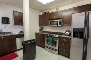 a kitchen with wooden cabinets and stainless steel appliances at Vernon Hostel in Vernon