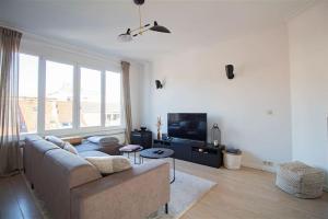 a living room with a couch and a tv at Plein centre de Waterloo! in Waterloo