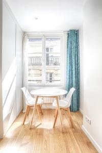 uma mesa e cadeiras num quarto com uma janela em Ciseaux 4F - Studio in Saint Germain des Prés em Paris
