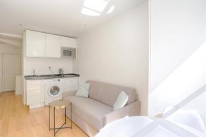 uma sala de estar com um sofá e uma máquina de lavar roupa em Ciseaux 4F - Studio in Saint Germain des Prés em Paris