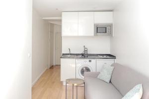 a kitchen with a couch and a sink and a washing machine at Ciseaux 4F - Saint Germain des Prés in Paris