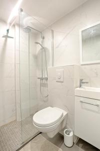 uma casa de banho branca com um WC e um chuveiro em Ciseaux 4F - Studio in Saint Germain des Prés em Paris