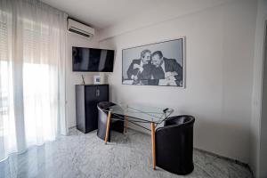 een woonkamer met een glazen tafel en een televisie bij Splendida camera vista mare con terrazza e finiture di lusso in Marina di Carrara