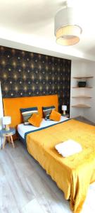 1 dormitorio con 1 cama grande con colcha amarilla en Le Vaisonnais - Calme et facile d'accès, en Vaison-la-Romaine
