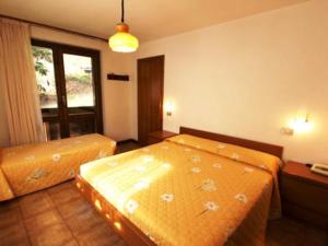 a hotel room with two beds and a window at Residence Valfurva in Santa Caterina Valfurva