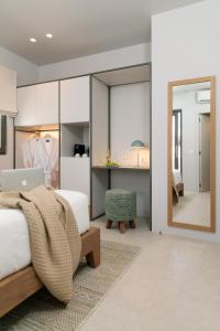 een slaapkamer met een bed en een spiegel bij Anapollo Boutique Hotel Adults Only in Naxos Chora