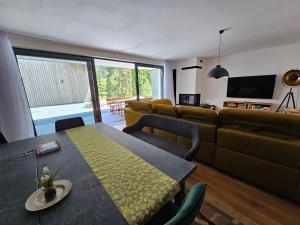 a living room with a couch and a dining room table at BudinSKI Apartmány & Wellness in Liptovský Mikuláš