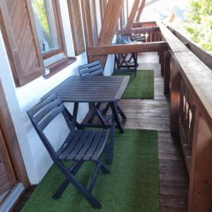 eine Reihe von Stühlen und ein Tisch auf einer Veranda in der Unterkunft Mountain view apartments in Bad Mitterndorf