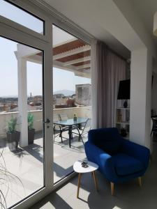 un salon avec une chaise bleue et un balcon dans l'établissement Appartamento Sul Golfo, à Castellammare del Golfo