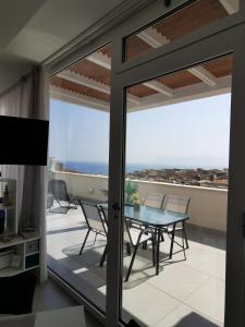 une porte en verre menant à un balcon avec une table et des chaises dans l'établissement Appartamento Sul Golfo, à Castellammare del Golfo