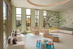 a living room with a childs room with furniture and windows at Titanic Deluxe Lara in Lara