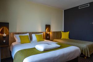 Ένα ή περισσότερα κρεβάτια σε δωμάτιο στο Kyriad Montchanin le Creusot