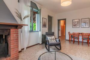 uma sala de estar com lareira e uma cadeira em Nel Verde di Rovenza by Wonderful Italy em Bellagio