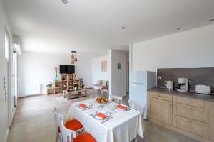 une cuisine avec une table et un chiffon de table blanc dans l'établissement Logis de la Perruche - Maison avec terrasses, à Montreuil-Bellay 5 autres photos